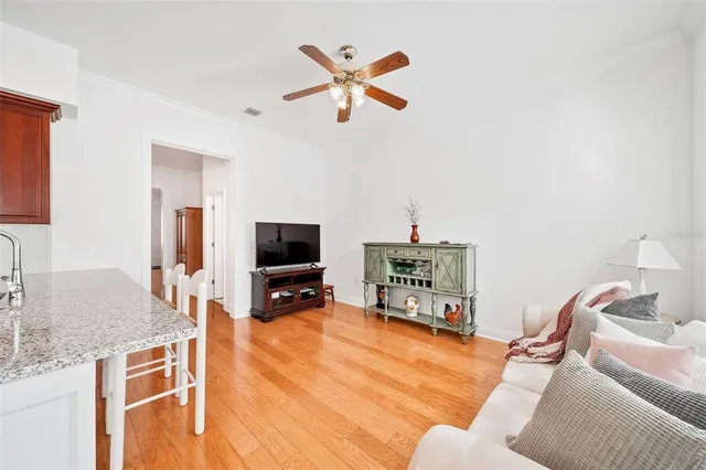 a living room with furniture and a flat screen tv with kitchen view