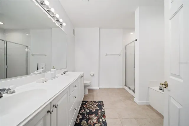 a spacious bathroom with a double vanity sink a mirror and a shower