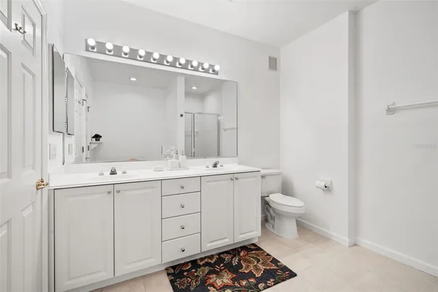 a bathroom with a double vanity sink mirror and toilet