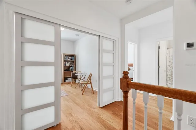 a view of a hallway with wooden floor and dining room