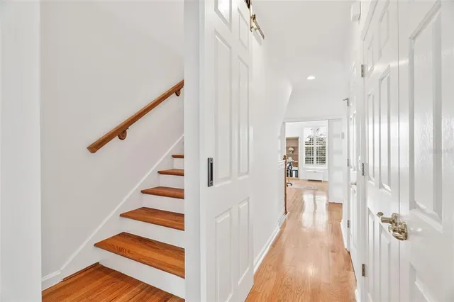 a view of a hallway with wooden floor and staircase