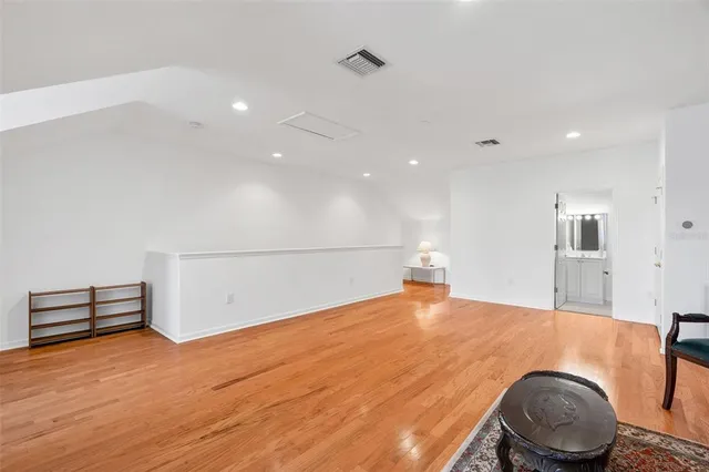 a view of an empty room with furniture and wooden floor