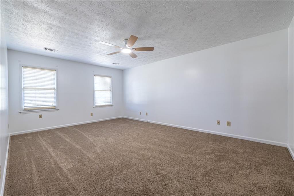 1465 Pounds Road Southwest Lilburn, GA 30047 - Photo 14 of 30 an empty room with windows and fan
