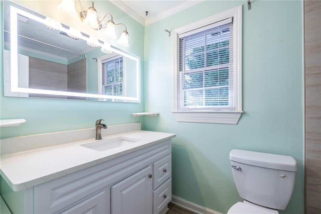 1465 Pounds Road Southwest Lilburn, GA 30047 - Photo 15 of 30 a bathroom with a sink a toilet and a mirror