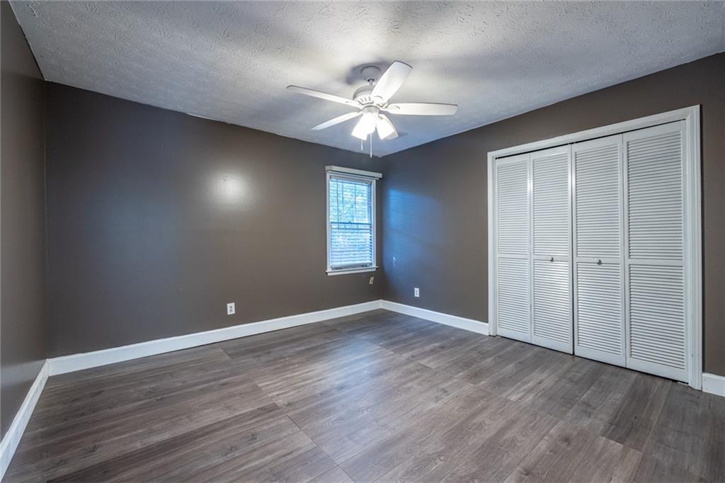 1465 Pounds Road Southwest Lilburn, GA 30047 - Photo 18 of 30 wooden floor in an empty room with a window