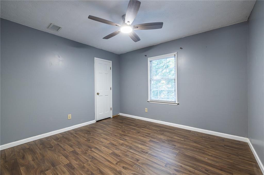 1465 Pounds Road Southwest Lilburn, GA 30047 - Photo 19 of 30 a view of empty room with wooden floor and fan