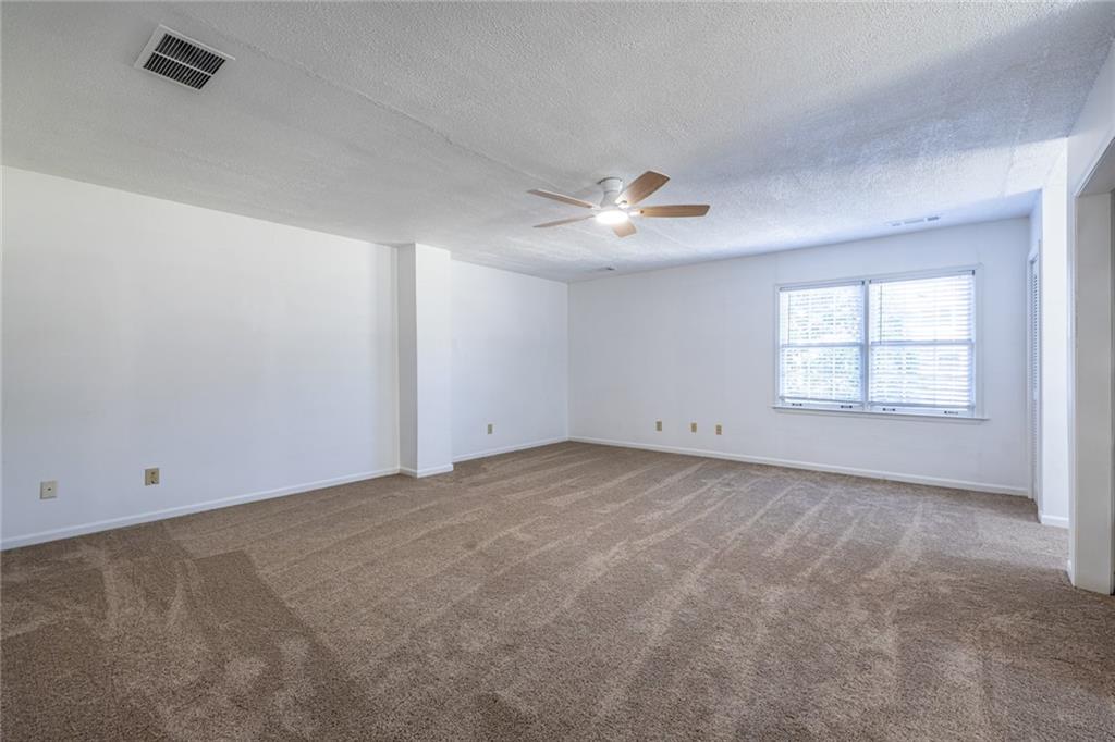1465 Pounds Road Southwest Lilburn, GA 30047 - Photo 20 of 30 an empty room with windows and ceiling fan
