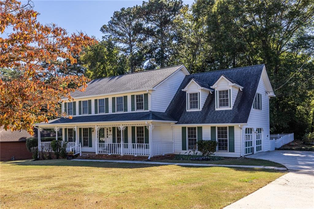 1465 Pounds Road Southwest Lilburn, GA 30047 - Photo 2 of 30 a view of a large pool with lawn chairs under an umbrella