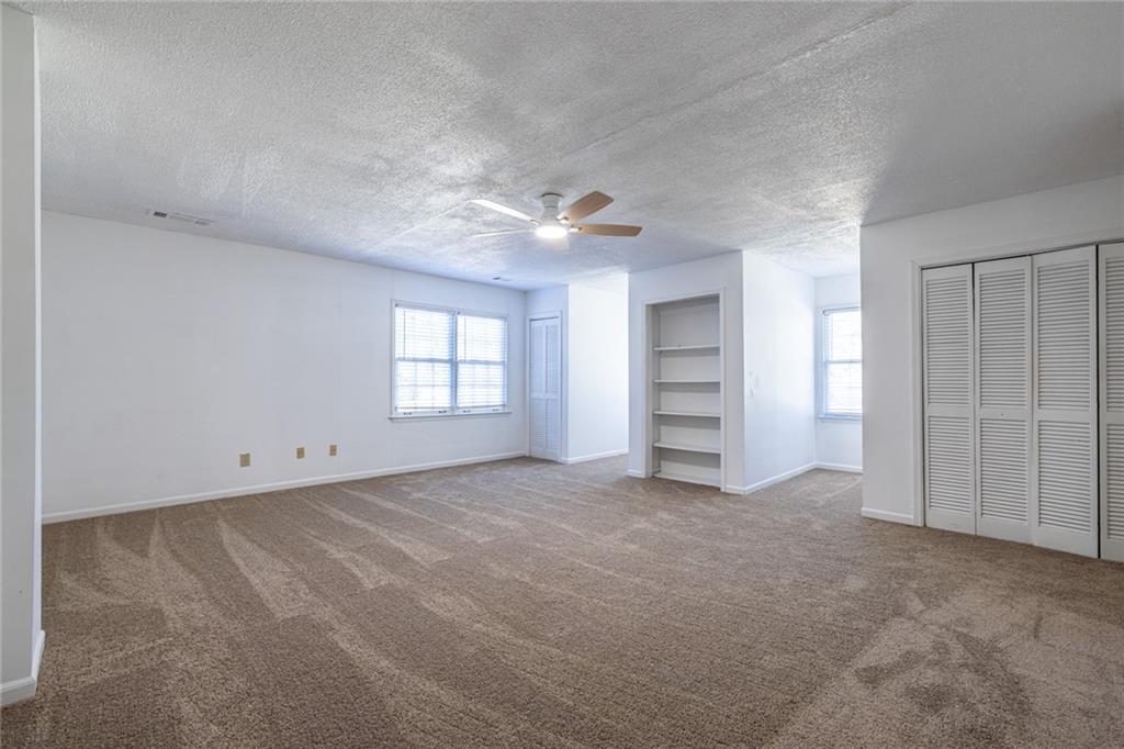 1465 Pounds Road Southwest Lilburn, GA 30047 - Photo 21 of 30 an empty room with windows and closet