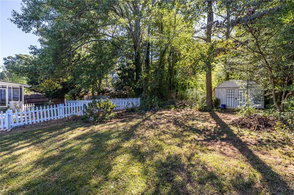 1465 Pounds Road Southwest Lilburn, GA 30047 - Photo 29 of 30 a view of a backyard with wooden fence and a bench