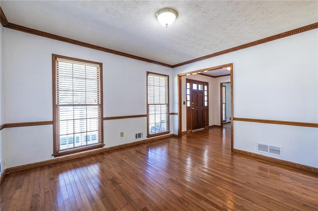 1465 Pounds Road Southwest Lilburn, GA 30047 - Photo 7 of 30 wooden floor in an empty room with a window
