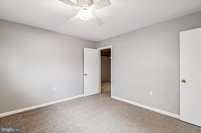 an empty room with fan and windows