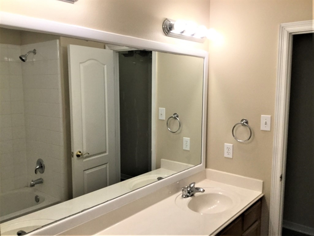 2213 Perkins Crossing Drive Conroe, TX 77304 - Photo 15 of 19 a bathroom with a sink a mirror and a shower