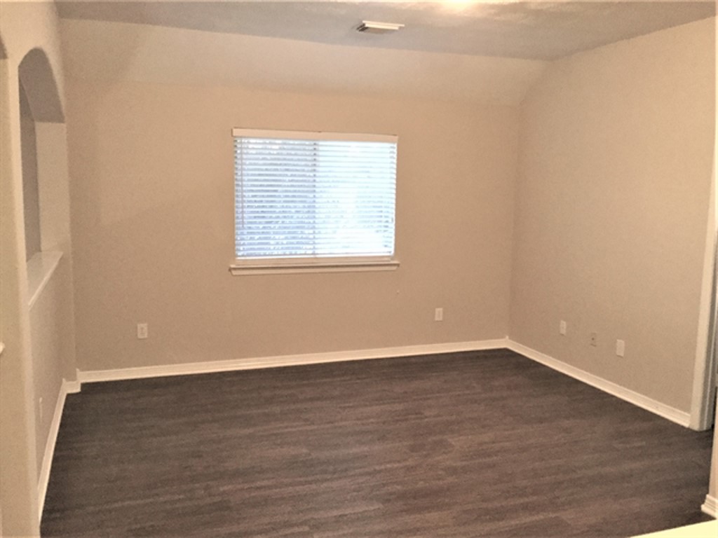2213 Perkins Crossing Drive Conroe, TX 77304 - Photo 8 of 19 an empty room with wooden floor and windows