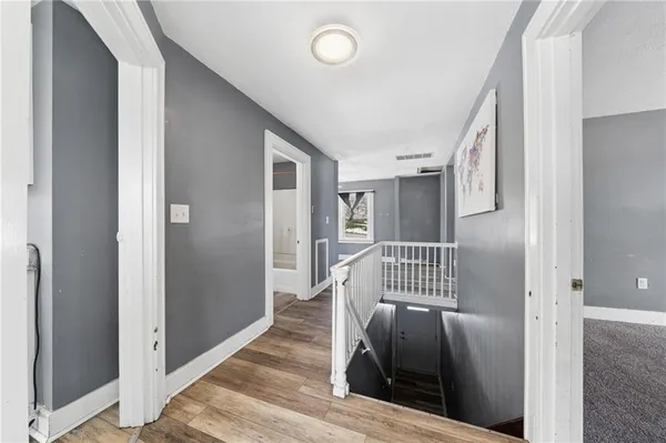 a view of a hallway with wooden staircase