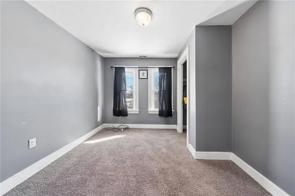 an empty room with closet and windows