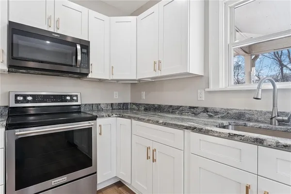a kitchen with cabinets stainless steel appliances a sink and a microwave