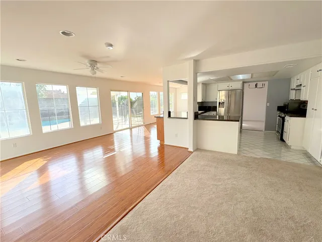 a view of a big room with wooden floor and a kitchen
