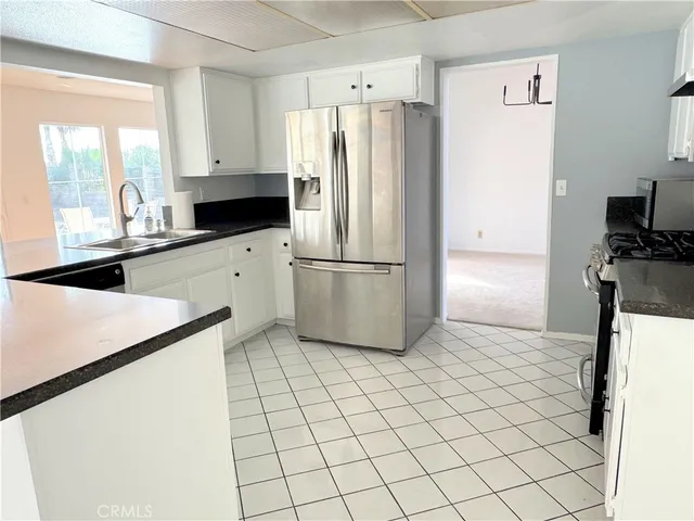 a large white bathroom with a granite countertop sink and a mirror