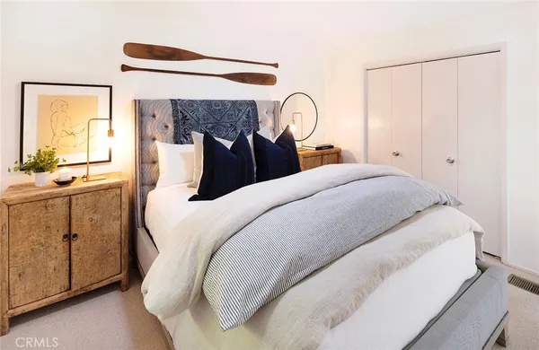 a bedroom with a large bed and a chandelier