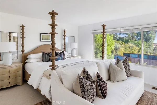 a bed sitting in a bedroom next to a window