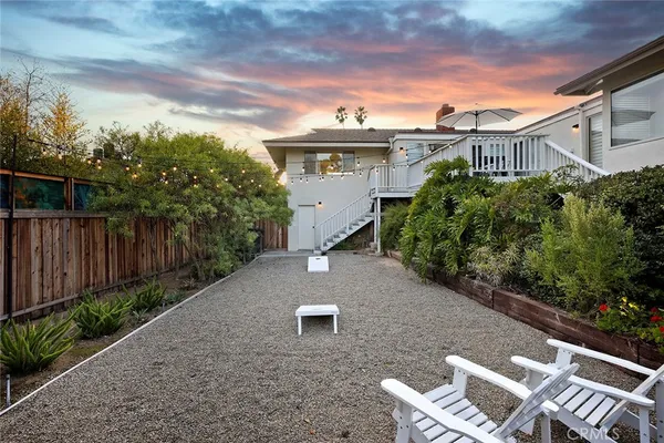 a view of a white house with a yard and potted plants