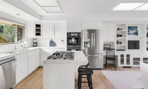 a kitchen with a refrigerator and a stove top oven