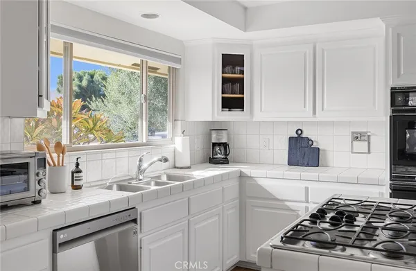 a kitchen with stainless steel appliances a sink stove and window