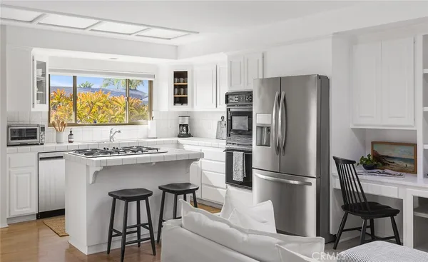 a kitchen with stainless steel appliances a refrigerator a stove a sink and a refrigerator