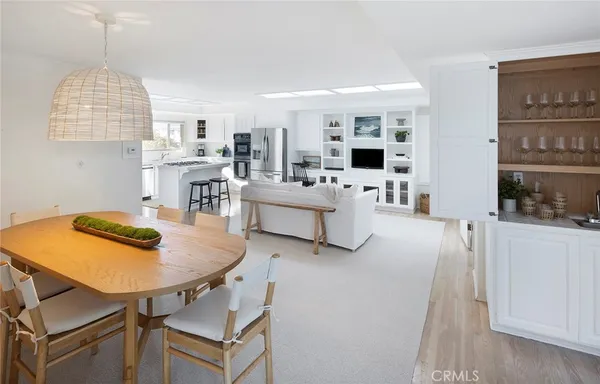 a living room with furniture a flat screen tv and kitchen view