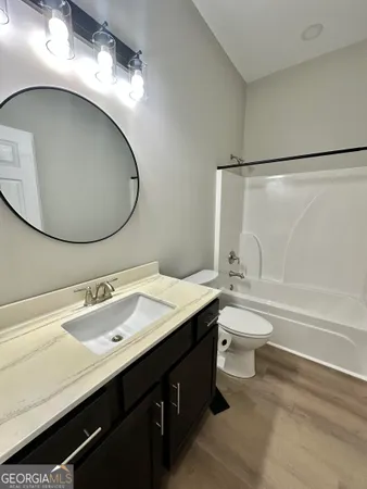a bathroom with a double vanity sink toilet and a mirror