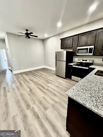 a kitchen with stainless steel appliances granite countertop a sink stove and refrigerator