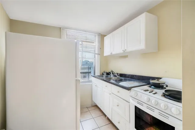 a kitchen with granite countertop a sink stove and cabinets