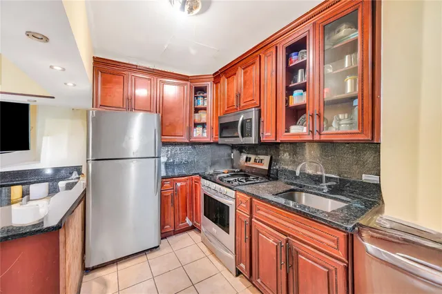 a kitchen with stainless steel appliances granite countertop a refrigerator and a sink