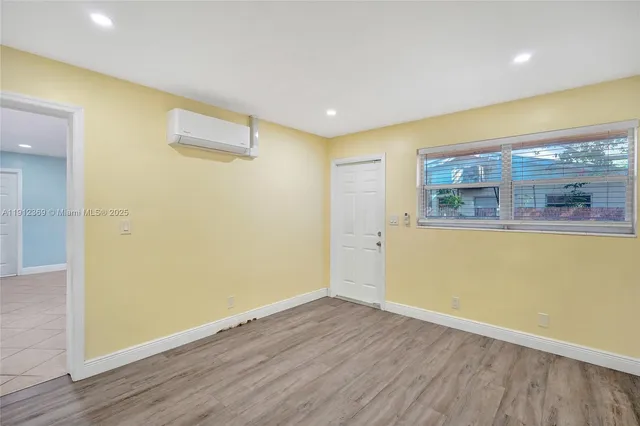 a view of a room with wooden floor and a ceiling fan