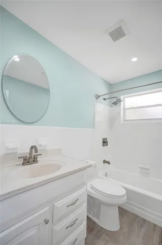 a bathroom with a toilet a sink a mirror and bathtub