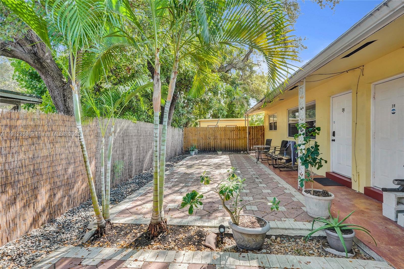 720 Southeast 15th Street, Unit 1 Fort Lauderdale, FL 33316 - Photo 32 of 38 a view of a patio with table and chairs potted plants and large tree
