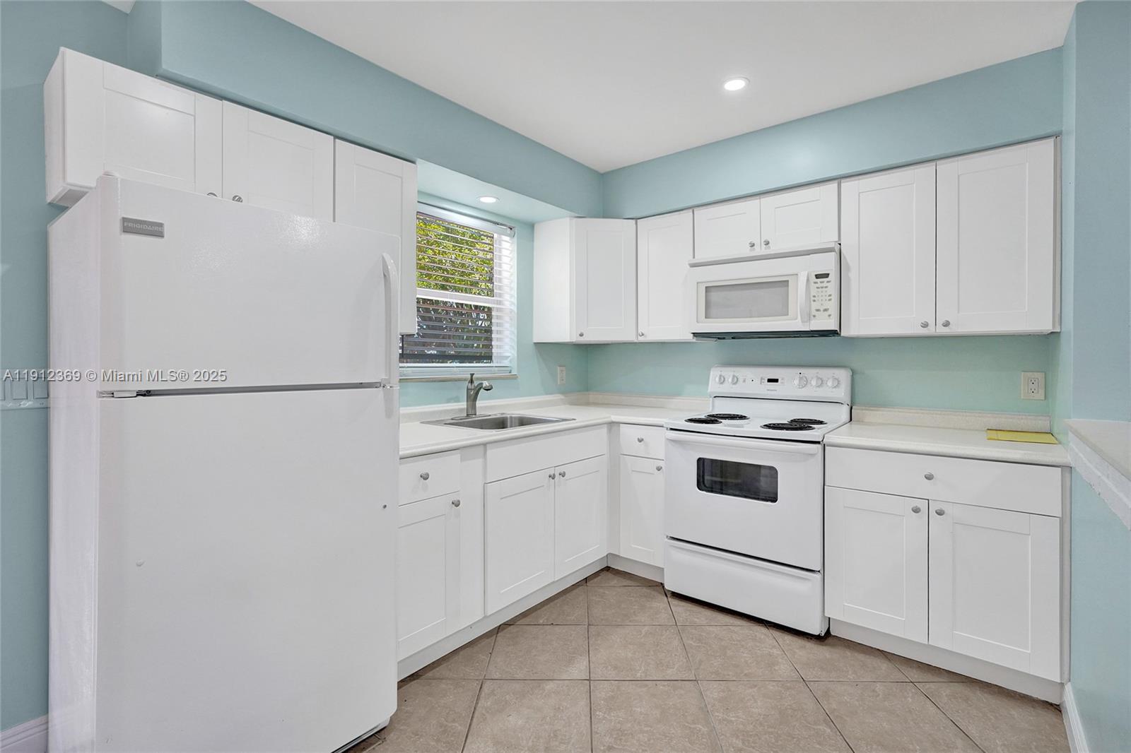 720 Southeast 15th Street, Unit 1 Fort Lauderdale, FL 33316 - Photo 5 of 38 a kitchen with cabinets appliances a sink and a window