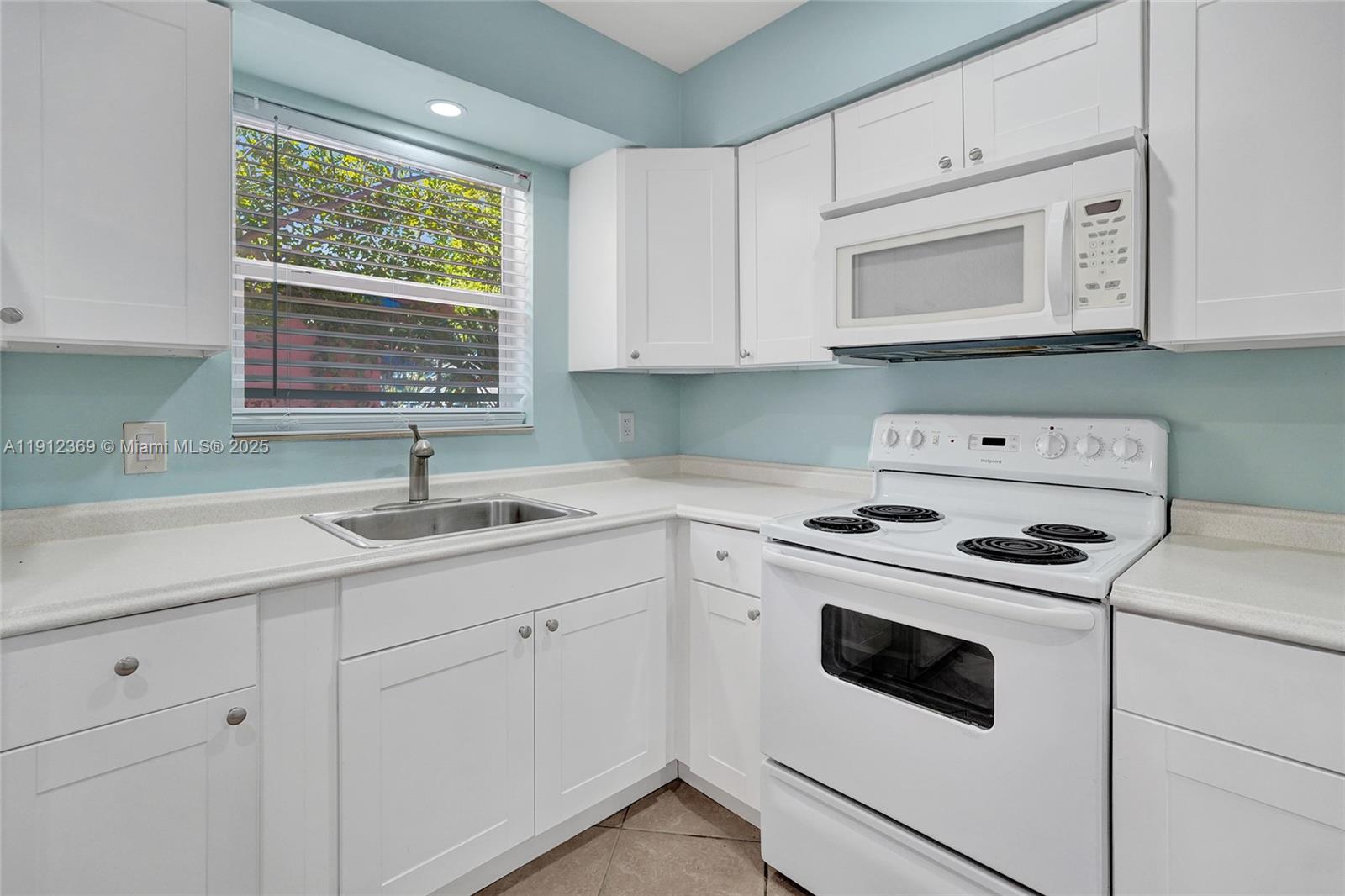 720 Southeast 15th Street, Unit 1 Fort Lauderdale, FL 33316 - Photo 6 of 38 a kitchen with white cabinets appliances and sink