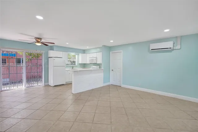 a kitchen with white cabinets and refrigerator