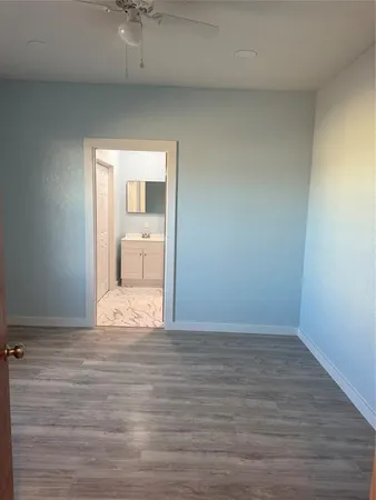 a view of a room with wooden floor and a ceiling fan