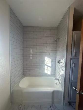 a bathroom with a bathtub and window