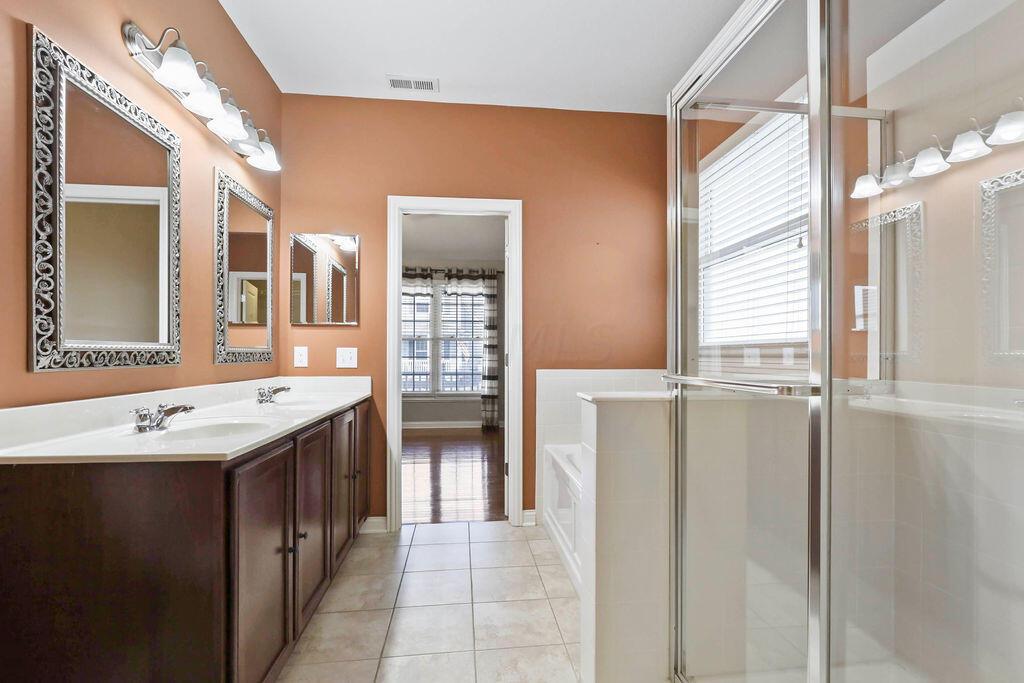 6163 Jennis Road Westerville, OH 43081 - Photo 15 of 44 • Ceramic tile flooring
• Paprika painted walls
• Enclosed vanity with double
bowl, cultured marble sinktop
• Garden tub with ceramic tile
surround
• Shower stall with glass
enclosure & ceramic tile
surround
• Ceiling exhaust
• 5 bulb wall light
• Mirrored medicine cabinet
• 2” blinds