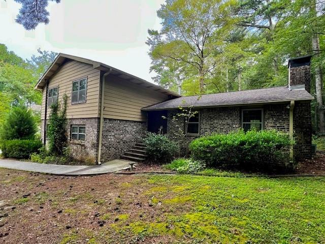 4541 Arcado Road Southwest Lilburn, GA 30047 - Photo 1 of 16 a view of a house with a small yard plants and large tree
