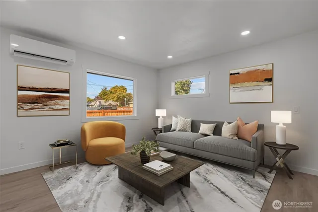 a living room with furniture a rug and wall paintings