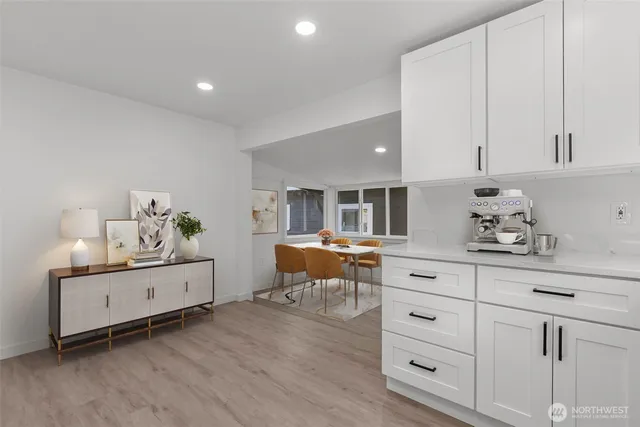 a kitchen with white cabinets and window