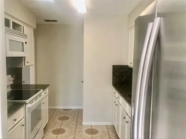 a kitchen with a refrigerator and cabinets