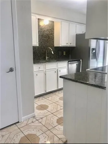 a kitchen with stainless steel appliances granite countertop a refrigerator sink and cabinets