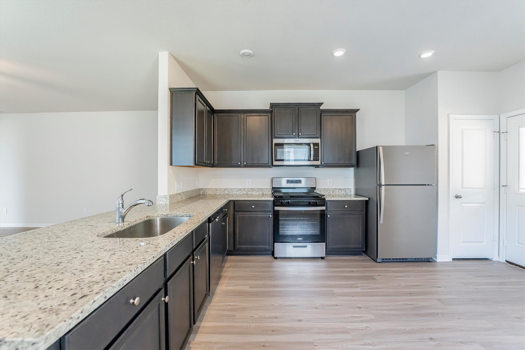 15419 Maple Ter Drive Conroe, TX 77303 - Photo 13 of 32 a kitchen with granite countertop a refrigerator stove top oven and sink