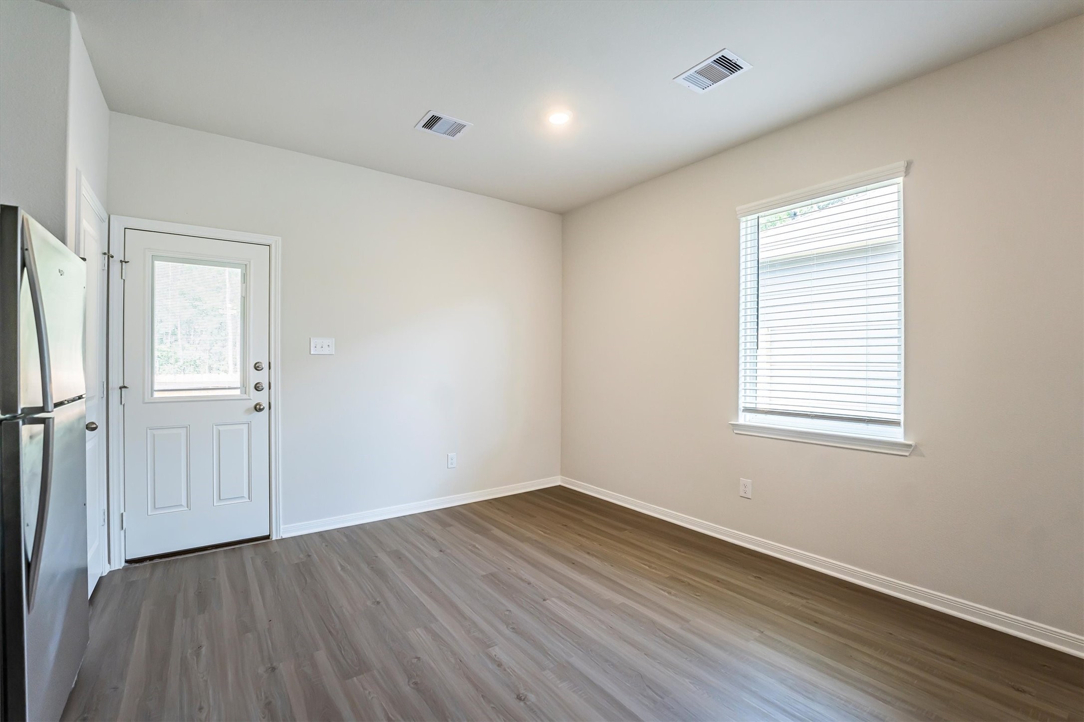 15419 Maple Ter Drive Conroe, TX 77303 - Photo 15 of 32 an empty room with wooden floor and windows